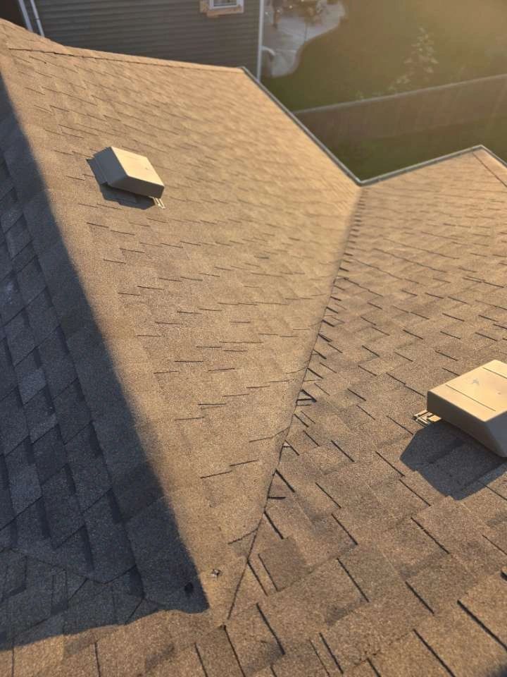 Wisconsin roofing professionals performing residential roof repair under warm daylight